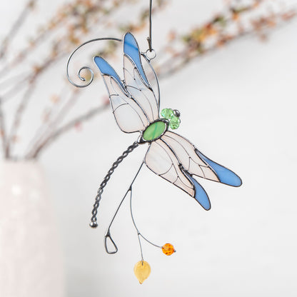 Dragonfly suncatcher with translucent wings and blue edges, green gem body, and amber and yellow bead accents.