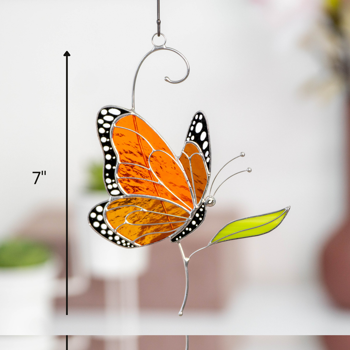 Stained glass butterfly side view hanging decor with size guide showing it's 7 inches height and modern background.