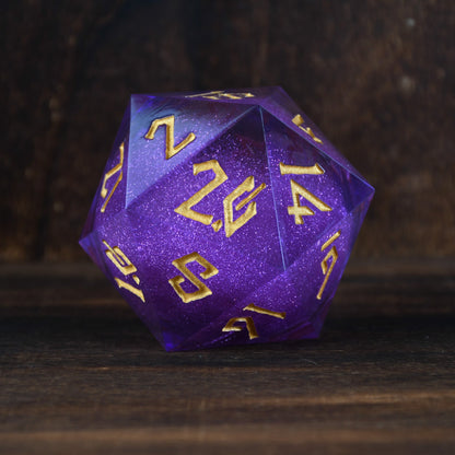 A large, purple, 20-sided die with engraved numbers in gold, surrounded by a wooden backdrop.