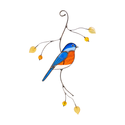 Hanging stained glass suncatcher of a bright blue and orange bluebird with yellow leaves on a curved branch