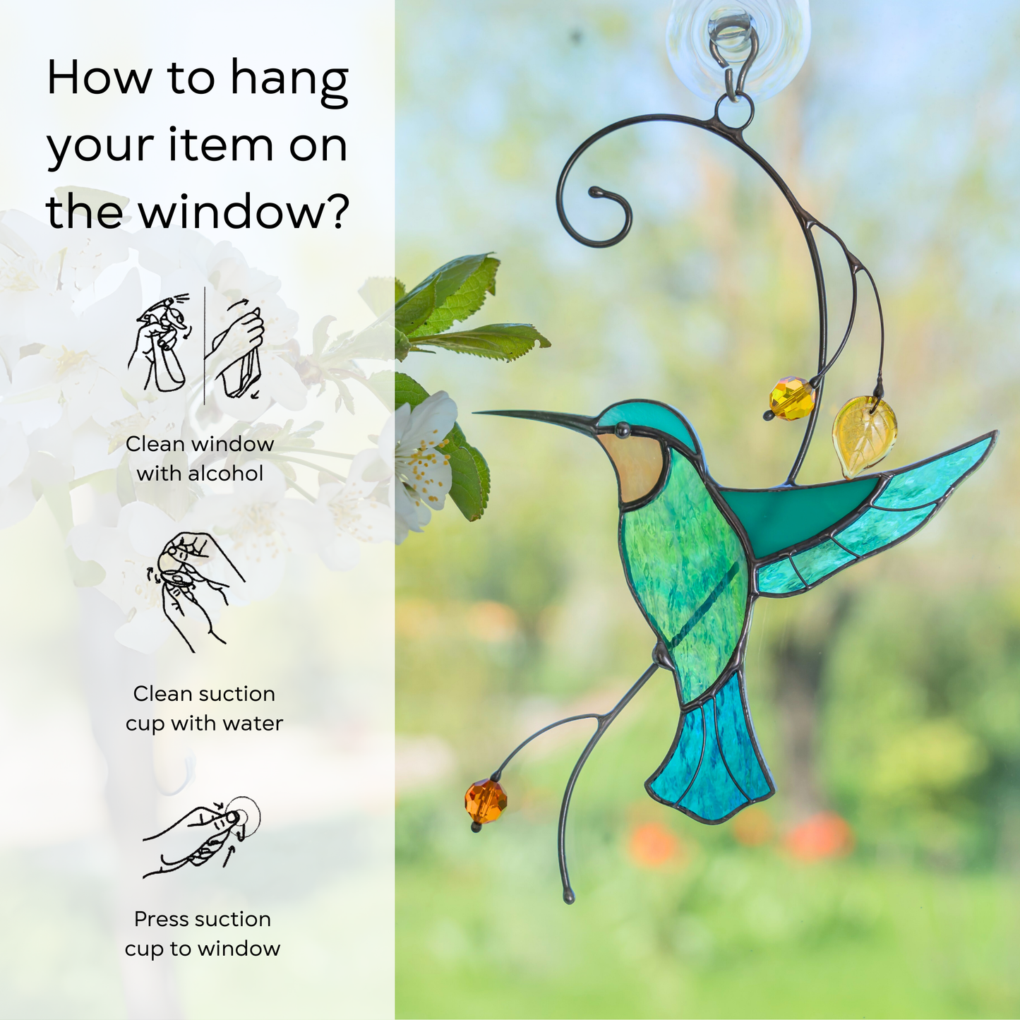 A delicate glass hummingbird yellow beads hanging in a window with greenery in the background