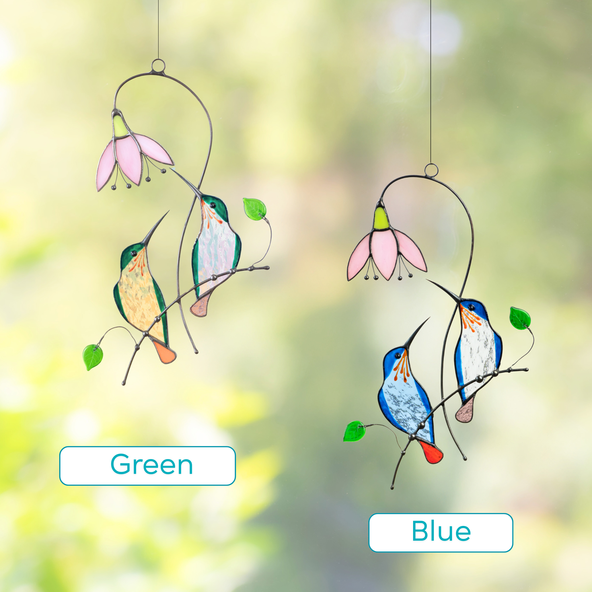 Two stained glass suncatchers featuring hummingbird pairs in green and blue, each near a pink flower.