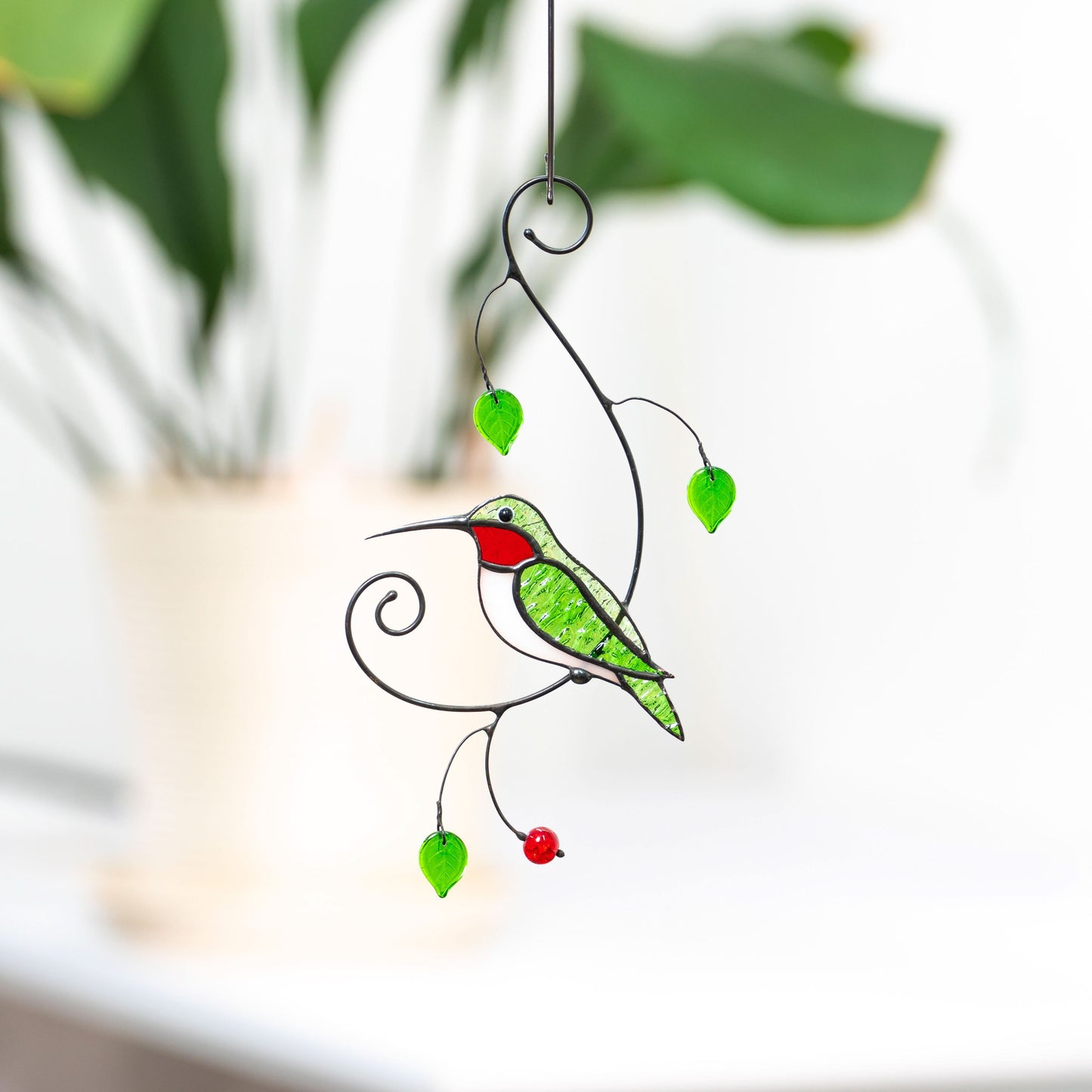 Stained glass hummingbird suncatcher with red throat and green wings.