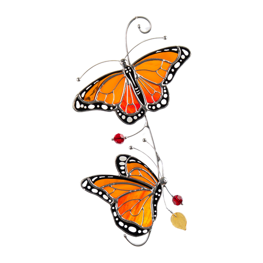Two orange monarch butterflies crafted from stained glass with black and white details.