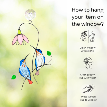 Pair of blue stained glass suncatcher hanging on the window with hanging instructions beside: clean window and suction cup, press a cup to the surface